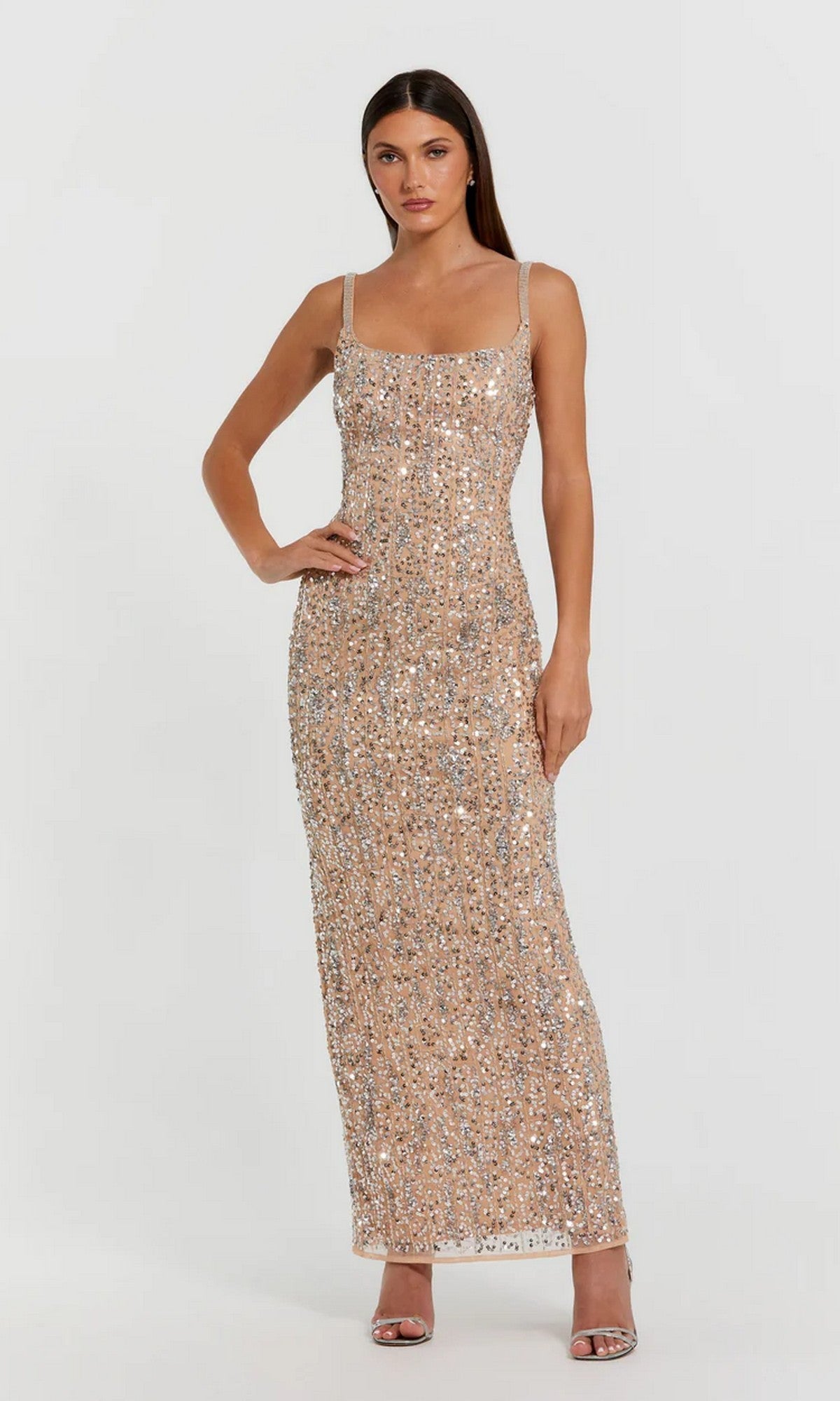 A woman wears the Mac Duggal 10696 Long Formal Dress in Nude Silver, sleeveless and floor-length, paired with open-toe heels against a plain light background.